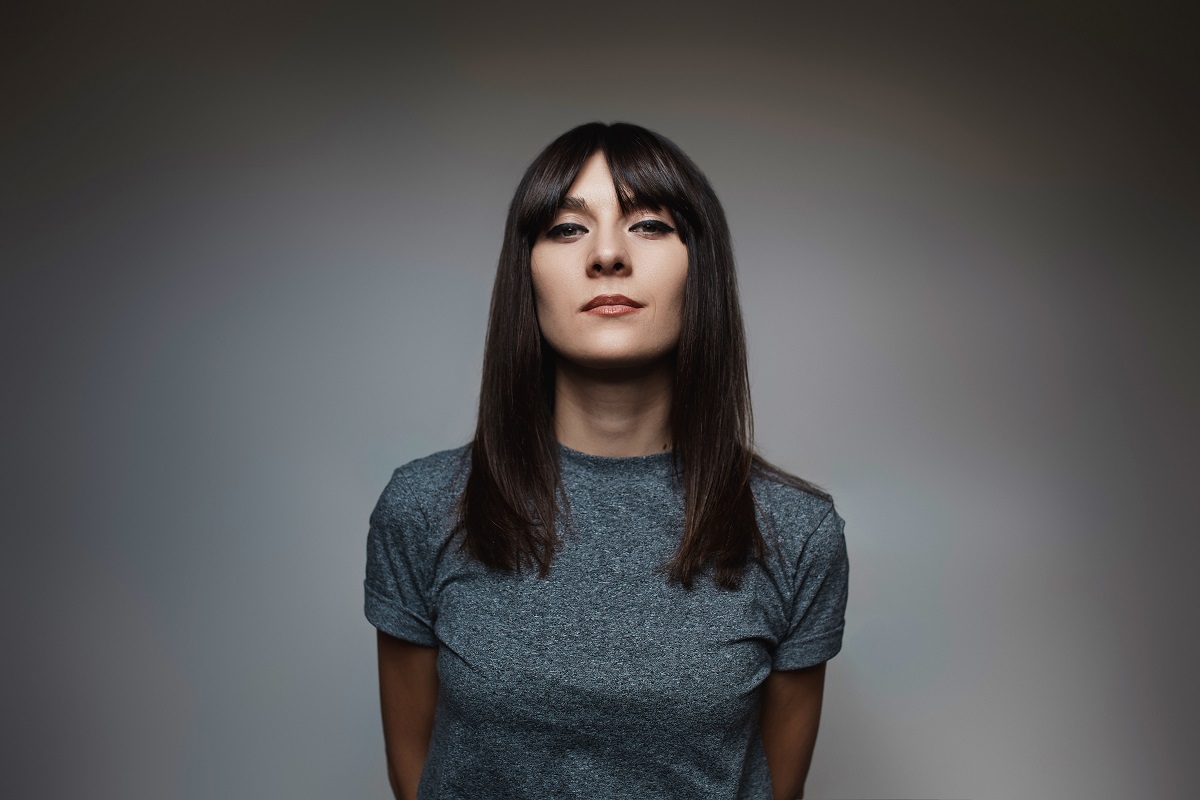 woman with a distinct square jawline, featuring curtain bangs